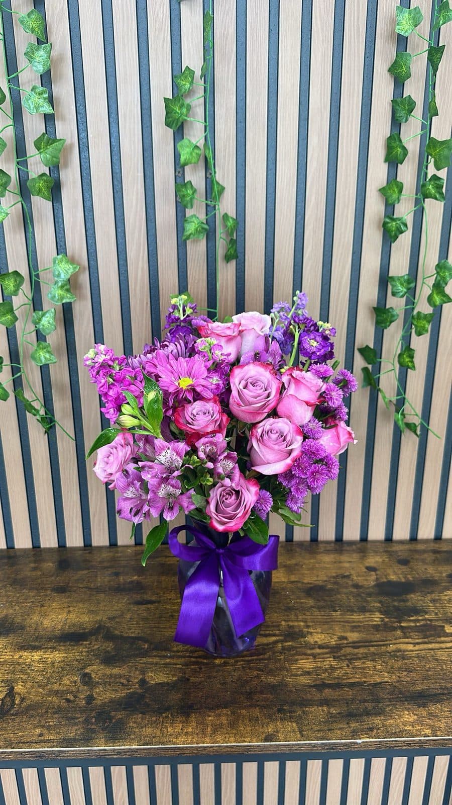 Before: purple roses and mums in a glass vase, photographed in the shop